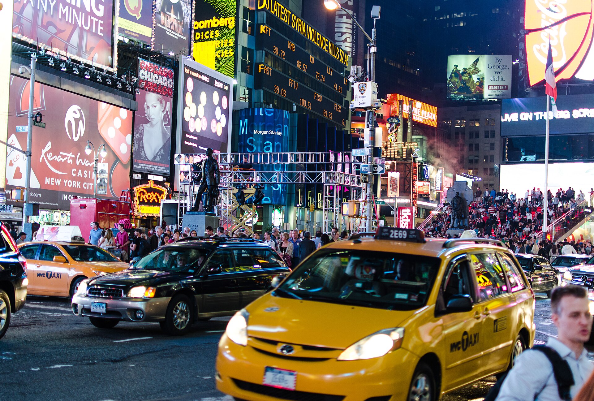 Times Square in Manhattan at night, crowded with lit billboards